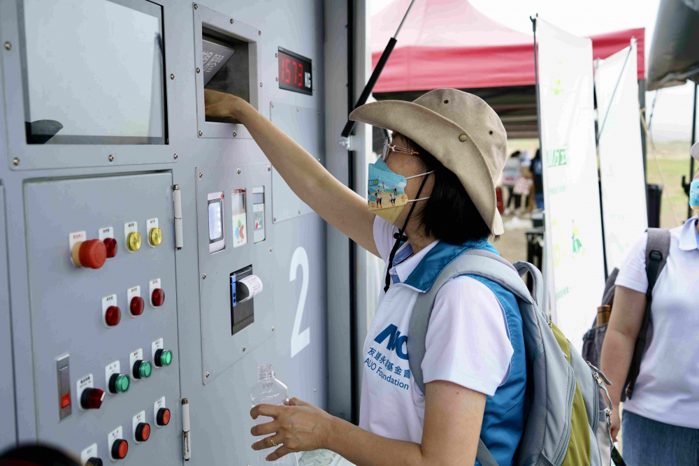 志工們將拾起的寶特瓶投入「好歸塑專車」，讓廢棄塑料空瓶可以直接粉碎、縮小體積，未來將可再製成購物袋、寶特衣、悠遊卡等生活用品